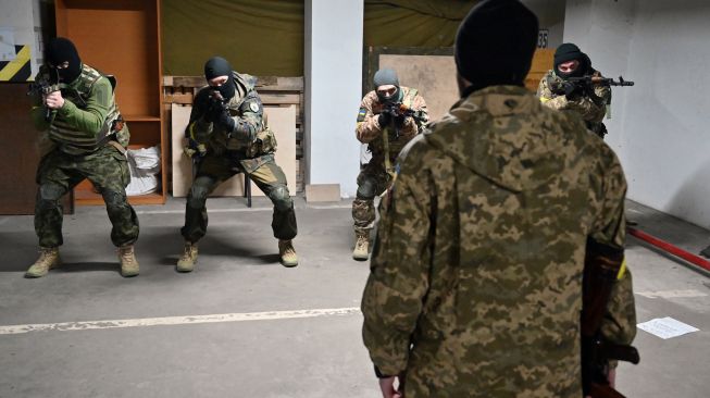 Prajurit Pasukan Pertahanan Teritorial Ukraina mengikuti pelatihan militer di garasi bawah tanah yang telah diubah menjadi pangkalan pelatihan dan logistik di Kyiv, Ukraina, Jumat (11/3/2022). [Sergei SUPINSKY / AFP]