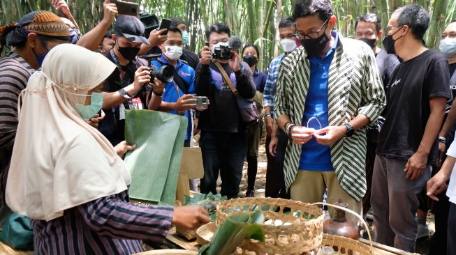 Menparekraf Sandiaga Uno (kedua kanan) membeli jajanan tradisional saat mengunjungi Pasar Papringan Ngadiprono, Kedu, Temanggung, Jawa Tengah, Minggu (13/3/2022). [ANTARA FOTO/Anis Efizudin/hp]