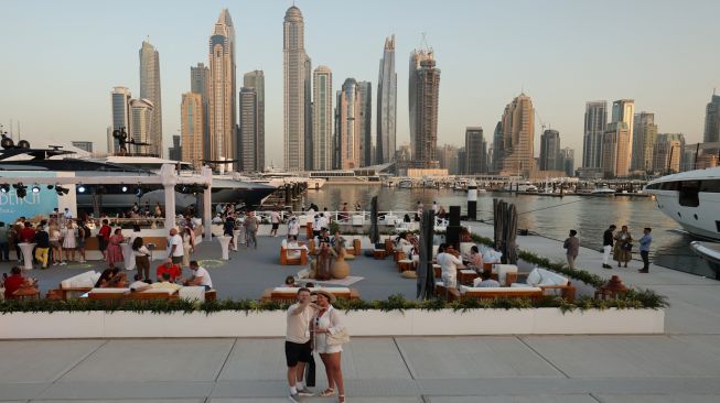 Orang-orang mengunjungi Dubai International Boat Show di Uni Emirat Arab, Minggu (13/2/2022). [Karim SAHIB / AFP]