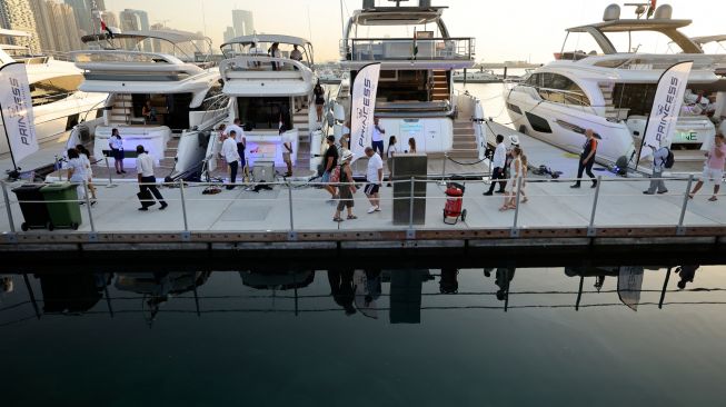 Orang-orang mengunjungi Dubai International Boat Show di Uni Emirat Arab, Minggu (13/2/2022). [Karim SAHIB / AFP]