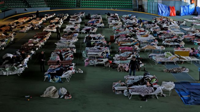 Para pengungsi dari Ukraina berlindung di aula utama kompleks atletik di ibukota Kishinev, Moldova, Kamis (10/3/2022). [MENAHEM KAHANA / AFP]