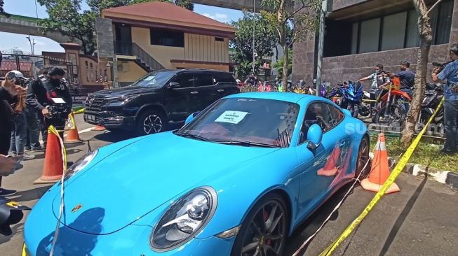 Salah satu mobil mewah dengan merek Porsche milik Doni Salmanan yang disita polisi. [Rena Pangesti/Suara.com]