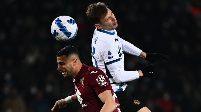 PGelandang Torino Rolando Mandragora (kiri) dan gelandang Inter Milan Nicolo Barella beradu sundulan saat pertandingan sepak bola Serie A Liga Italia antara Torino dan Inter Milan di stadion Olimpiade, Turin, Italia, Sabtu (13/3/2022). [Marco BERTORELLO / AFP]