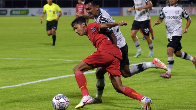 Pesepak bola Persija Jakarta Dony Tri Pamungkas (kiri) berebut bola dengan pesepak bola Persikabo 1973 Gilang Ginarsa (tengah) pada pertandingan Liga 1 di Stadion Kompyang Sujana, Denpasar, Bali, Minggu (13/3/2022). [ANTARA FOTO/Nyoman Hendra Wibowo/hp]