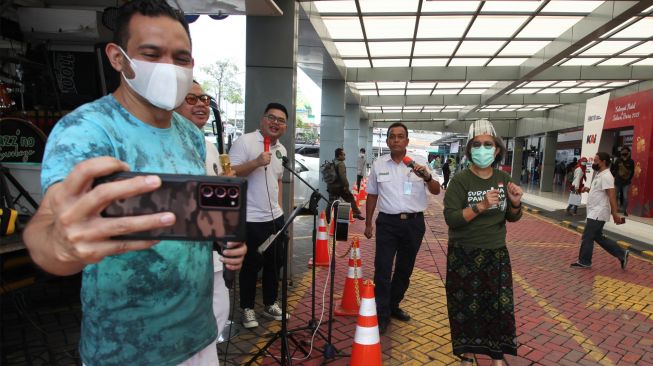 Penyanyi Ivan Saba (kiri) dan anggota Komisi XI DPR Indah Kurnia (kanan) bernyanyi bersama diiringi kelompok musik Orange saat digelarnya Surabaya Pahlawan Jazz di halaman Stasiun Pasar Turi Surabaya, Jawa Timur, Senin (14/3/2022). [ANTARA FOTO/Didik Suhartono/aww]