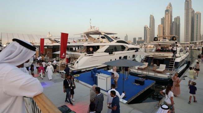 Orang-orang mengunjungi Dubai International Boat Show di Uni Emirat Arab, Minggu (13/2/2022). [Karim SAHIB / AFP]