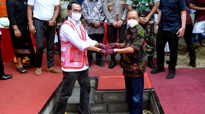 Menteri Perhubungan Budi Karya Sumadi (kiri) berfoto dengan Gubernur Bali Wayan Koster (kanan) usai meletakkan batu pertama proyek revitalisasi bangunan gedung VVIP Bandara Internasional I Gusti Ngurah Rai di Badung, Bali, Minggu (13/3/2022). [ANTARA FOTO/Fikri Yusuf/hp]
