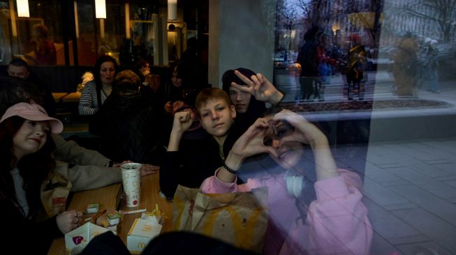 Para pengunjung berpose di dalamrestoran McDonald's di Pushkinskaya Square di pusat kota Moskow, Rusia, Minggu (13/3/2022). [AFP]