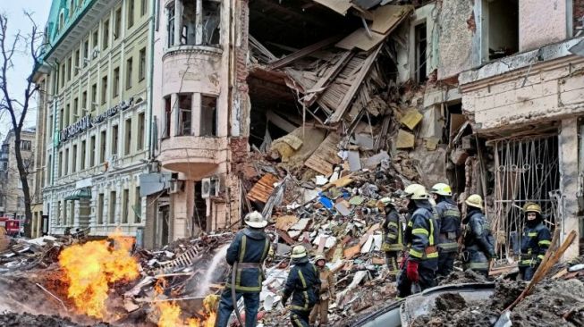 Tim penyelamat bekerja di samping bangunan yang rusak akibat serangan udara, saat serangan Rusia ke Ukraina terus berlanjut. [Dok.Antara]