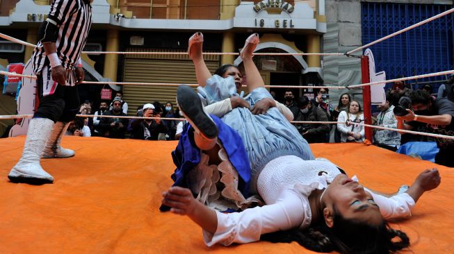 Para pegulat Cholitas tampil bertarung gulat saat festival Electro Preste di La Paz, Bolivia, Sabtu (12/3/2022). [JORGE BERNAL / AFP]