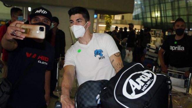 Pebalap MotoGP dari tim Aprilia Racing (aprilia) Maverick Vinales (tengah) berswafoto dengan penggemarnya setibanya di Bandara Soekarno Hatta,Tangerang, Banten, Selasa (15/3/2022). ANTARA FOTO/Muhammad Iqbal