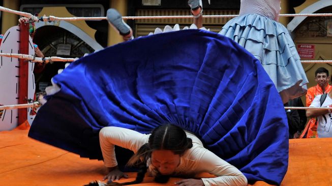 Para pegulat Cholitas tampil bertarung gulat saat festival Electro Preste di La Paz, Bolivia, Sabtu (12/3/2022). [JORGE BERNAL / AFP]