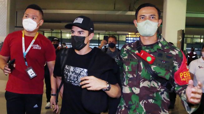 Pebalap MotoGP dari tim Repsol Honda Marc Marquez (tengah) setibanya di Bandara Soekarno Hatta,Tangerang, Banten, Selasa (15/3/2022).  ANTARA FOTO/Muhammad Iqbal