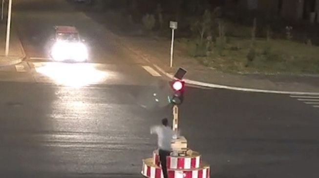 Pria robohkan lampu lalu lintas karena tidak betah menunggu lampu merah. (saostar.vn)