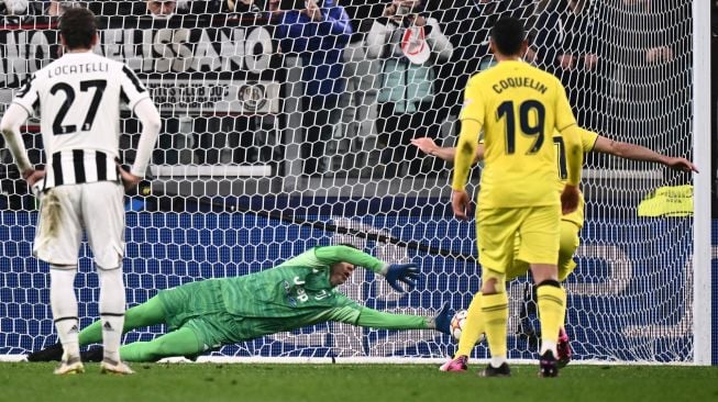 Penjaga gawang Juventus Wojciech Szczesny gagal menahan penalti dari pemain depan Villarreal Gerard Moreno (Kanan depan) saat pertandingan leg kedua babak 16 besar UEFA Liga Champions antara Juventus dan Villareal di Stadion Juventus, Turin, Italia, Rabu (17/3/2022). [Marco BERTORELLO / AFP]