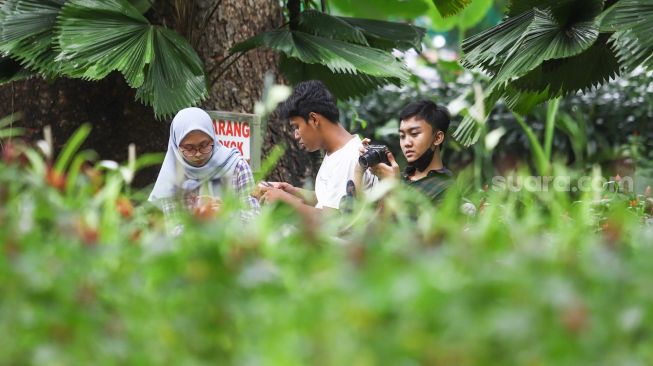 Warga mengunjungi Taman Suropati di Jakarta Pusat, Jumat (18/3/2022). [Suara.com/Alfian Winanto]