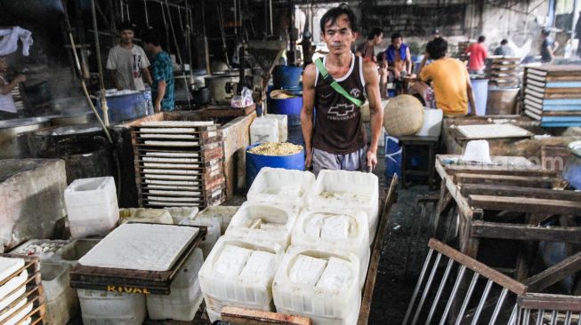 Pekerja memproduksi tahu dan tempe berbahan dasar kedelai di kawasan Duren Tiga Raya, Jakarta selatan, Jumat (18/3/2022). [Suara.com/Alfian Winanto]