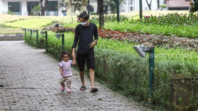 Warga mengunjungi Taman Suropati di Jakarta Pusat, Jumat (18/3/2022). [Suara.com/Alfian Winanto]