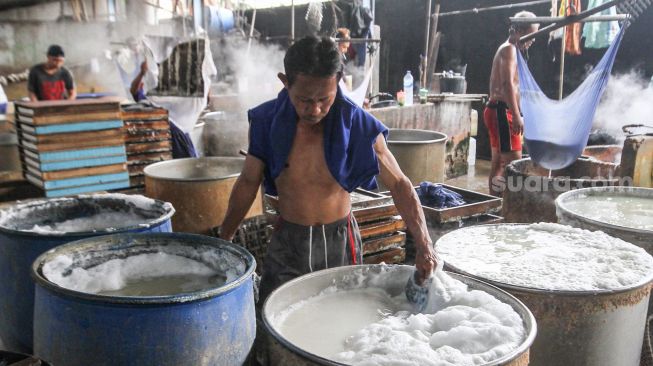 Pekerja memproduksi tahu dan tempe berbahan dasar kedelai di kawasan Duren Tiga Raya, Jakarta selatan, Jumat (18/3/2022). [Suara.com/Alfian Winanto]