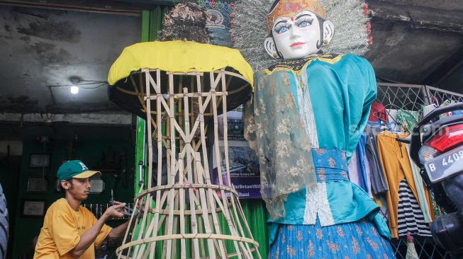 Perajin membuat patung ondel-ondel di Sanggar Betawi Rifky Albani di Jakarta, Jumat  (18/3/2022).[Suara.com/Septian]