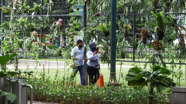 Warga mengunjungi Taman Suropati di Jakarta Pusat, Jumat (18/3/2022). [Suara.com/Alfian Winanto]