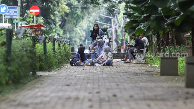 Warga mengunjungi Taman Suropati di Jakarta Pusat, Jumat (18/3/2022). [Suara.com/Alfian Winanto]