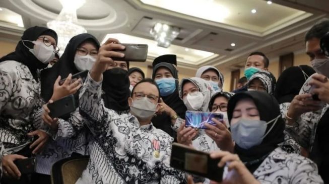 Gubernur DKI Jakarta Anies Baswedan berfoto bersama dengan para guru saat hadir dalam Konferensi Kerja Provinsi II PGRI DKI Jakarta, Jumat (18/3/2022). [Instagram@aniesbaswedan]