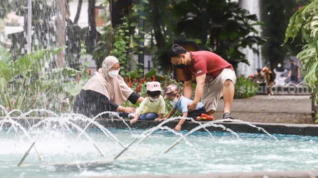 Warga mengunjungi Taman Suropati di Jakarta Pusat, Jumat (18/3/2022). [Suara.com/Alfian Winanto]