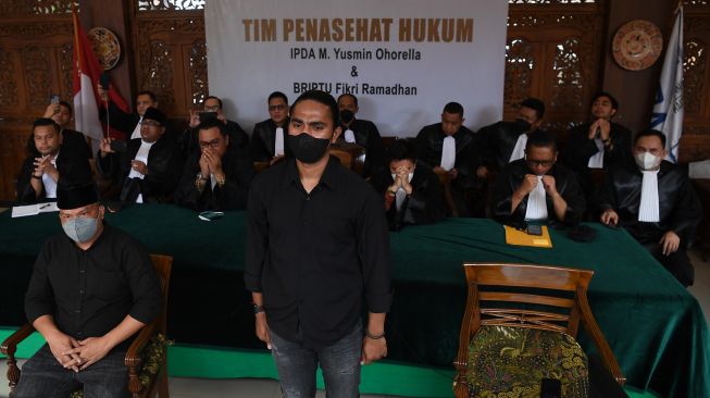 Terdakwa �unlawful killing� anggota Laskar FPI Briptu Fikri Ramadhan (kanan) dan Ipda M Yusmin Ohorella (kiri) mendengarkan pembacaan putusan dalam sidang yang digelar secara virtual di Jakarta, Jumat (18/3/2022)