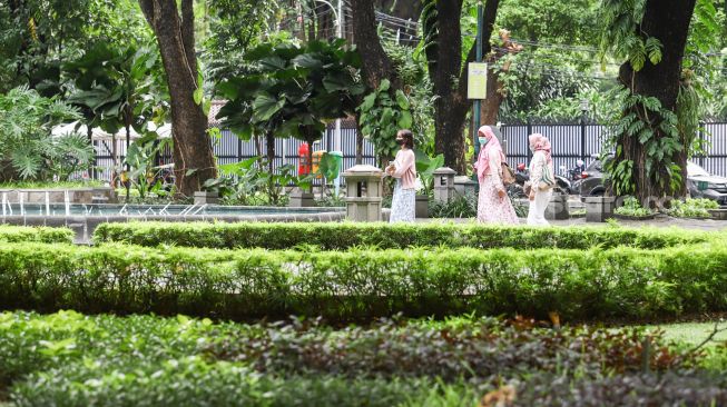 Warga mengunjungi Taman Suropati di Jakarta Pusat, Jumat (18/3/2022). [Suara.com/Alfian Winanto]