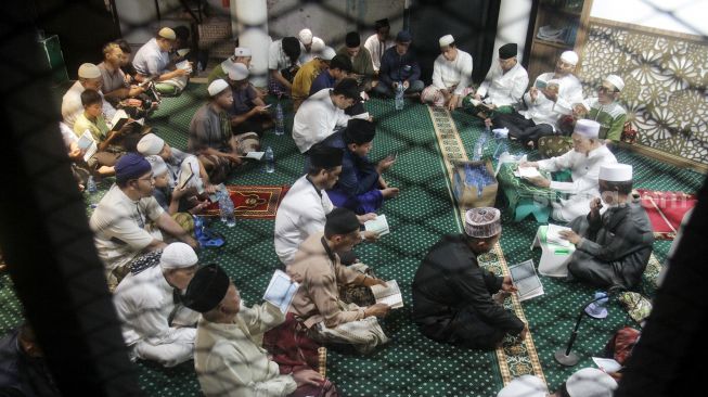 Umat muslim membaca surah Yasin di malam nisfu Syaban 15 Sya'ban 1443 Hijriah di Masjid Nurul Huda, Jakarta, Kamis (17/3/2022).  [Suara.com/Oke Atmaja]