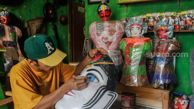 Perajin membuat patung ondel-ondel di Sanggar Betawi Rifky Albani di Jakarta, Jumat  (18/3/2022).[Suara.com/Septian]