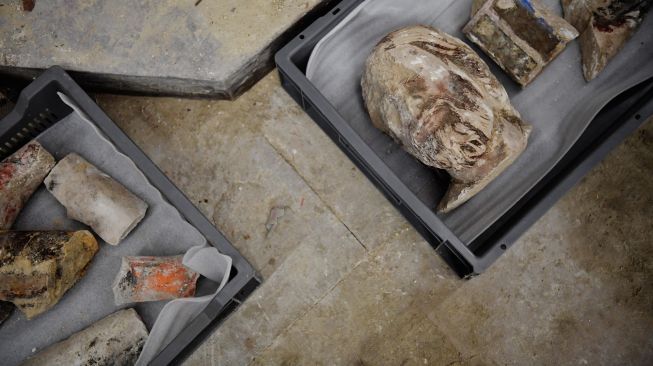 Benda-benda antik lain yang ditemukan para arkeolog di lantai Katedral Notre Dame setelah penemuan sarkofagus atau peti mati kuno dari abad ke-14 di Paris, Prancis, Selasa (15/3/2022). [JULIEN DE ROSA / AFP] 
