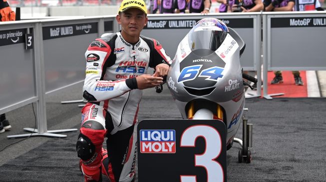 Pebalap Indonesia Mario Suryo Aji yang tergabung dalam Honda Team Asia berpose dengan sepeda motornya usai sesi kualifikasi Moto3 seri Pertamina Grand Prix of Indonesia 2022 di Pertamina Mandalika International Street Circuit, Lombok Tengah, NTB, Sabtu (19/3/2022). ANTARA FOTO/Andika Wahyu/nz.