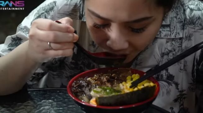 Nagita Slavina menyantap Okinawa Ramen, salah satu menu andalan Papa Ramen, jajanan yang viral. (YouTube/Rans Entertainment)