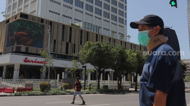 Warga berjalan di depan Gedung Sarinah pascarenovasi di Jakarta, Minggu (20/3/2022). [Suara.com/Angga Budhiyanto]