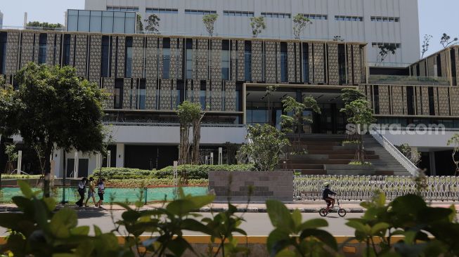 Pesepeda melintas di depan Gedung Sarinah pascarenovasi di Jakarta, Minggu (20/3/2022). [Suara.com/Angga Budhiyanto]