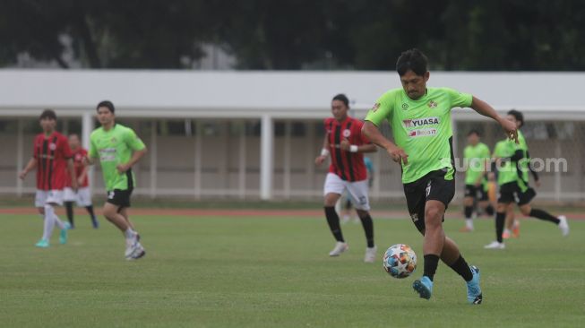 Aktor Ibnu Jamil menggiring bola saat bermain sepakbola bersama Selebritis FC di Stadion Madya, Kompleks Gelora Bung Karno, Jakarta, Senin (21/3/2022). [Suara.com/Angga Budhiyanto]