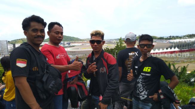 Arizal (kanan), pemuda asal Jambi, nekat mengendarai motor RX-King dari Jambi menuju Lombok untuk menyaksikan MotoGP Mandalika 2022, Minggu (20/3/2022). [Arief Apriadi/Suara.com]