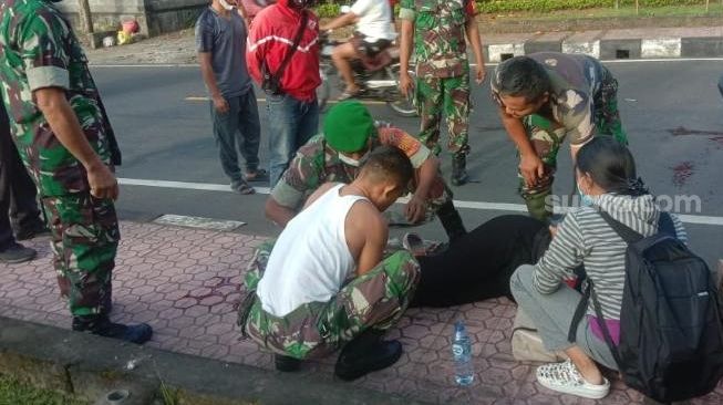 Sersan Satu Suparto, Bintara Pembina Desa (Babinsa) Semarapura Kelod Kangin, Klungkung, Bali membuka seragam dan melepas baju kaus bermotif loreng. Lalu merobeknya untuk menutup luka korban lakalantas [SuaraSulsel.id/Istimewa]