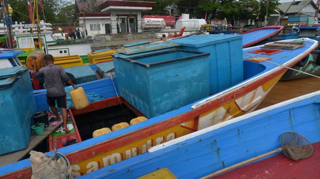 Nelayan memindahkan jeriken di kapal saat antre untuk mendapatkan minyak solar bersubsidi di Stasiun Pengisian Bahan Bakar Nelayan (SPBN) Pelabuhan Lampulo, Banda Aceh, Aceh, Senin (21/3/2022). ANTARA FOTO/Ampelsa