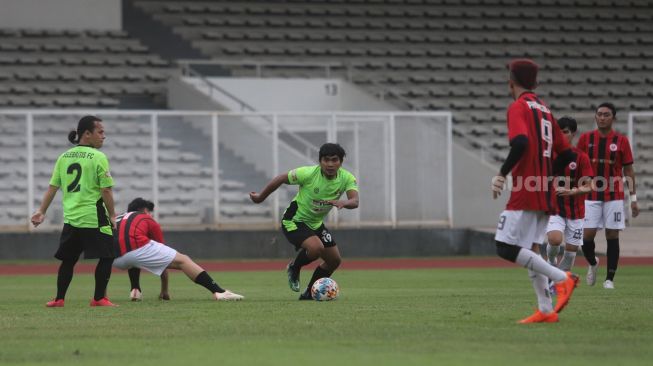 YouTuber Haris Saputra atau Maell Lee menggiring bola saat bermain sepakbola bersama Selebritis FC di Stadion Madya, Kompleks Gelora Bung Karno, Jakarta, Senin (21/3/2022). [Suara.com/Angga Budhiyanto]