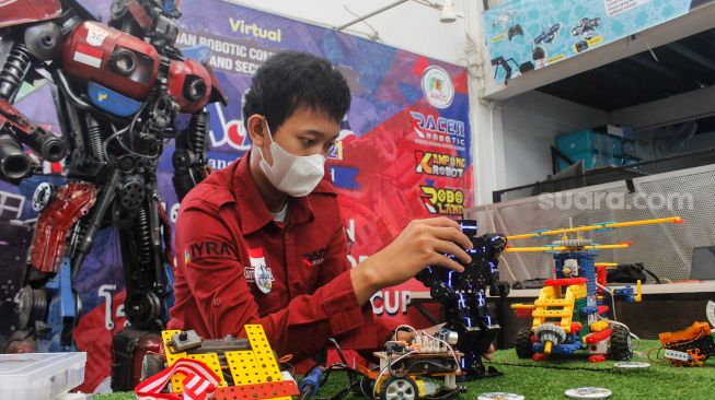 Seorang peserta pelatihan merakit Robot-robot hasil karyanya di Kampong Robot, Ciputat, Tangerang Selatan, Banten, Senin (22/3/2022).[Suara.com/Septian]