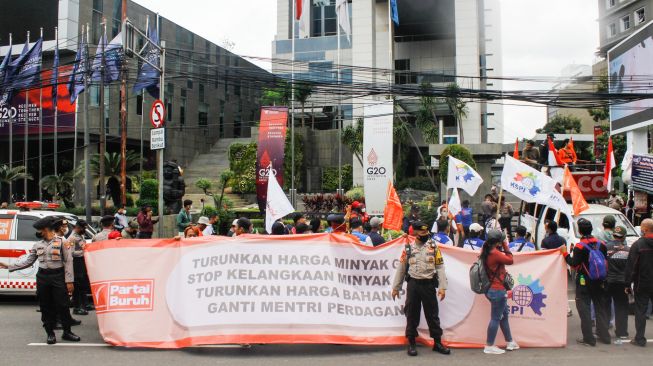 Massa dari Serikat Buruh dan Serikat Petani menggelar aksi unjuk rasa di depan kantor Kementerian Perdagangan, Gambir, Jakarta Pusat, Selasa (22/3/2022). [Suara.com/Alfian Winanto]