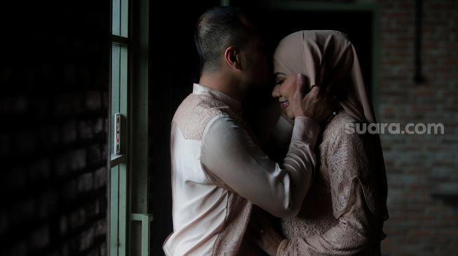 Pasangan artis Ferry Irawan dan Venna Melinda berpose sebelum acara resepsi pernikahan mereka di Studio TOHA, Ciputat, Tangerang Selatan, Banten, Rabu (23/3/2022). [Suara.com/Angga Budhiyanto]