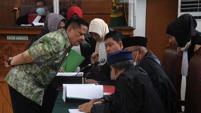 Terdakwa mantan Kadiv Hubungan Internasional (Hubinter) Polri Irjen Pol Napoleon Bonaparte berdiskusi dengan kuasa hukumnya saat menjalani sidang perdana kasus dugaan penganiayaan terhadap narapidana kasus penistaan agama Muhammad Kosman alias M. Kace di Pengadilan Negeri Jakarta Selatan, Kamis (24/3/2022). ANTARA FOTO/Indrianto Eko Suwarso