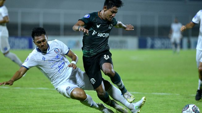 Pesepak bola Arema FC Rizky Dwi Febrianto (kiri) menghadang pesepak bola Persikabo 1973 Firza Andika (kanan) saat pertandingan Liga 1 di Stadion Kompyang Sujana, Denpasar, Bali, Kamis (24/3/2022). [ANTARA FOTO/Fikri Yusuf/hp]
