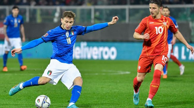 Gelandang Italia Nicolo Barella (kiri) mencoba untuk menembak tepat sasaran meski dihalangi gelandang Makedonia Utara Enis Bardhi saat pertandingan sepak bola play-off kualifikasi Piala Dunia 2022 antara Italia dan Makedonia Utara di stadion Renzo-Barbera, Palermo, Italia, Kamis (24/3/2022). [Alberto PIZZOLI / AFP]