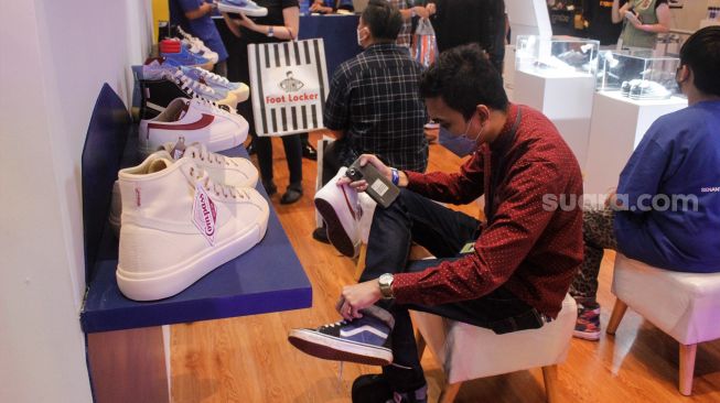 Pengunjung mencoba sepatu sneaker saat Event Jakarta Sneaker Day (JSD) di Mall Senayan City, Jakarta Pusat, Jumat (25/3/2022). [Suara.com/Septian]