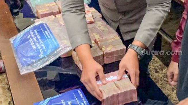 Barang bukti uang tunai milik Tersangka Indra Kesuma alias Indra Kenz ditampilkan saat rilis kasus dugaan penipuan berkedok trading binary option, Binomo di Bareskrim Mabes Polri, Jakarta Selatan, Jumat (25/3/2022). [Suara.com/Adiyoga Priyambodo]